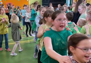 Uczniowie tańczą i śpiewają tworząc długiego węża.