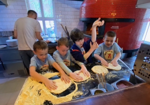 Czterej uczniowie robią placki do pizzy