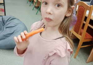 Dziewczynka je marchewkę