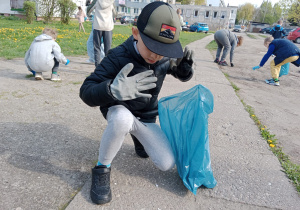 Chłopiec zbiera śmieci wokół szkoły