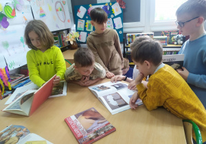 Dzieci oglądają albumy ze sztuką w bibliotece