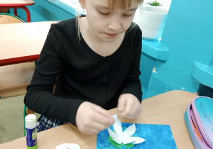 Dziewczynka wykonuje lilię wodną z papieru