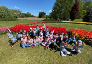 Zbiorowe zdjęcie uczniów na tle tulipanów.