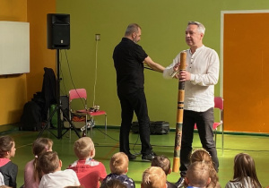 Muzyk prezentuje Didgeridoo drewniane.