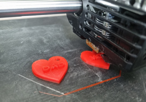 Z bliska pokazana jest głowica drukarki 3D wykonującej wydruk modelu
