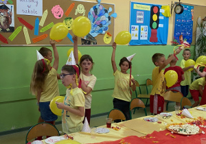Uczniowie tańczą z balonami.
