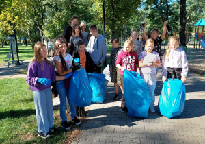 uczniowie z workami śmieci po zakończonej akcji