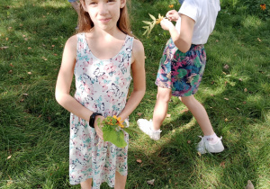 Dwie dziewczynki podczas zbierania jesiennych liści