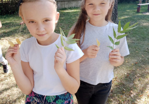 Dwie dziewczynki podczas zbierania jesiennych liści
