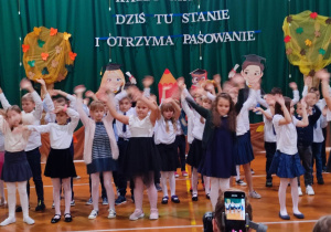 uczniowie klas 1 podczas występu, śpiewaja i tańczą