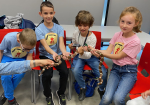Uczniowie trzymają węża.