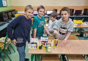 Czwórka chłopców prezentuje zbudowaną przez siebie stację pogodową.