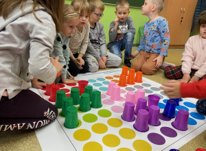 Dzieci ustawiają kolorowe kubeczki na macie do kodowania 1