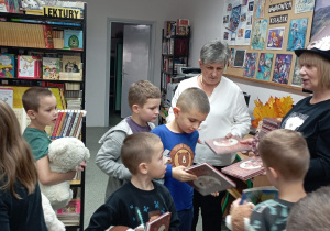 Dzieci oglądają książki, które wręczyła im pani dyrektor