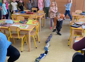 Dzieci w ciągu ustawiają swoje buty jeden za drugim.
