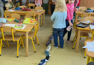 Dzieci w rzędzie ustawiają buty jeden za drugim.1