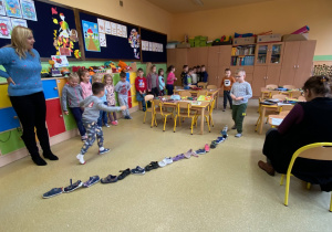 Dzieci w rzędzie ustawiają buty jeden za drugim.2