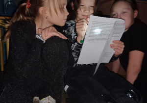 Dziewczynki czytają przy latarce