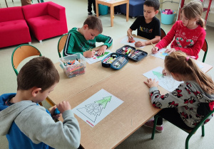 Grupa dzieci koloruje choinki