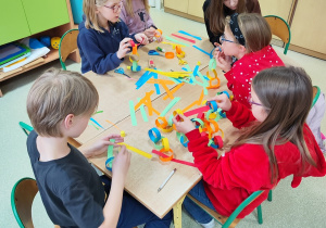 Dzieci tworzą łańcuch z kolorowego papieru