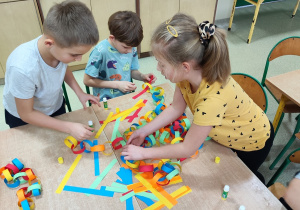 Dzieci tworzą łańcuch z kolorowego papieru