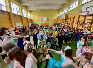 Uczniowie tańczą na sali tworząc gigantycznego węża.
