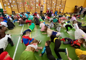 Uczniowie leżą na podłodze wykonując zadanie ruchowe.2