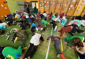 Uczniowie leżą na podłodze wykonując zadanie ruchowe.3