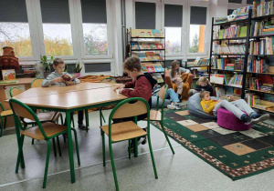 uczniowie czytający ksiażki w bibliotece