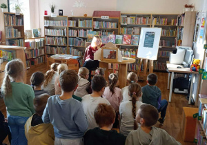 Uczniowie oglądają teatrzyk biblioteczny Kamishibai
