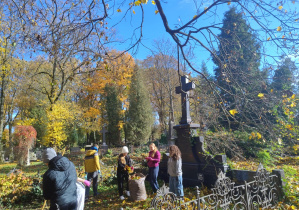 uczennice porządkują grób na Starym Cmentarzu w Łodzi