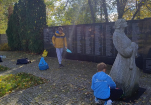 uczniowie 7a sprzątają miejsce pamięci dzieci pomordowanych w obozie w Konstantynowie Łódzkim.