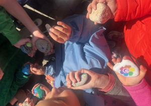 Dłonie uczniów z pomalowanymi kamieniami 2