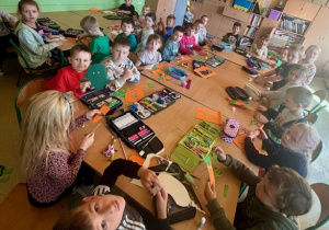 Uczniowie wycinają papierowe warzywa.