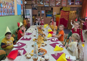 Uczniowie siedzą przy wspólnym urodzinowym stole 1.