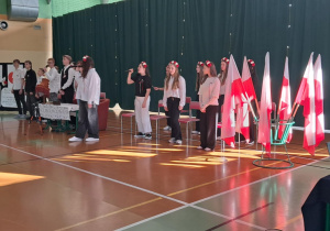 Uczniowie stoją obok flag