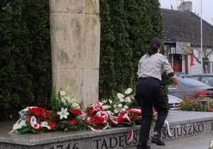 harcerka składa kwiaty pod pomnikiem Tadeusz Kościuszki