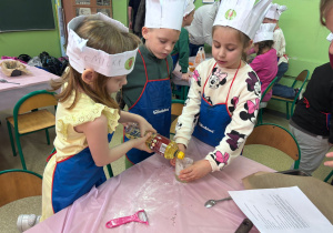 uczennica wlewa olej do szklanki