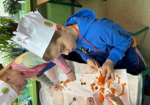 uczniowie obierają marchewkę