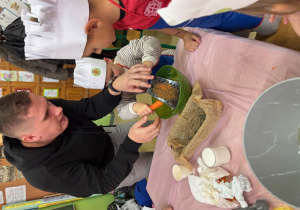 mężczyzna pomaga chłopcu zetrzeć marchew