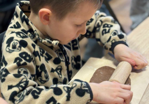 chłopiec w trakcie wyrabiania ciasta na pierniki