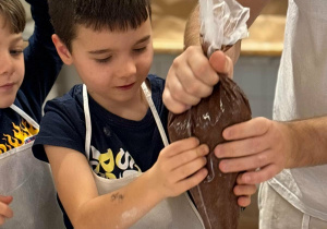 uczeń dodaje krem czekoladowy do babeczki