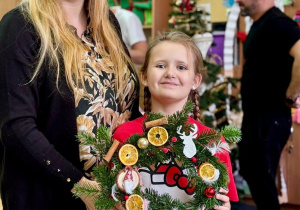uczennica z mamą i wieńcem bożonarodzeniowym