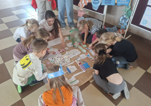 uczniowie w czasie kolorowania plakatu o zużyciu wody