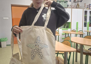 uczennica z torbą ekologiczną ozdobioną w rozgwiazdę.
