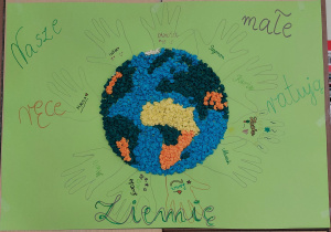 Ziemia otoczona papierowymi odrysami rąk dzieci