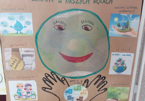 dłoń trzymającą miniaturowy ekosystem z panelem fotowoltanicznym i turbiną wiatrową