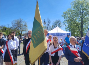 uczniowie stoją ze sztandarem szkoły
