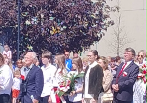 uczniowie podczas składania kwiatów pod pomnikiem
