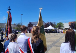 uczniowie w czasie uroczystości, trzymają sztandar szkoły